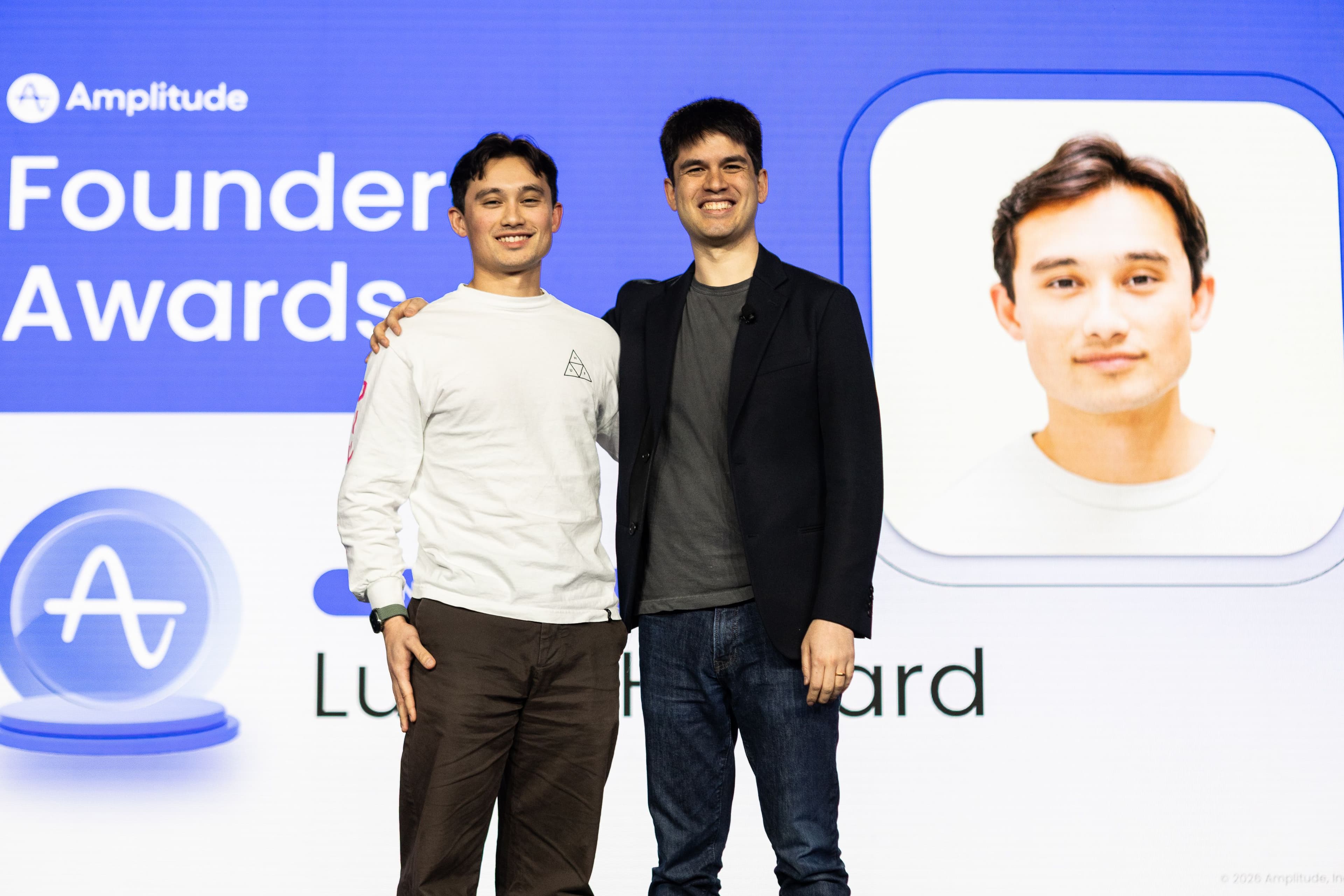 Lucas Howard with Amplitude CEO Spenser Skates on stage acknowledging his 2025 Founders' Award.