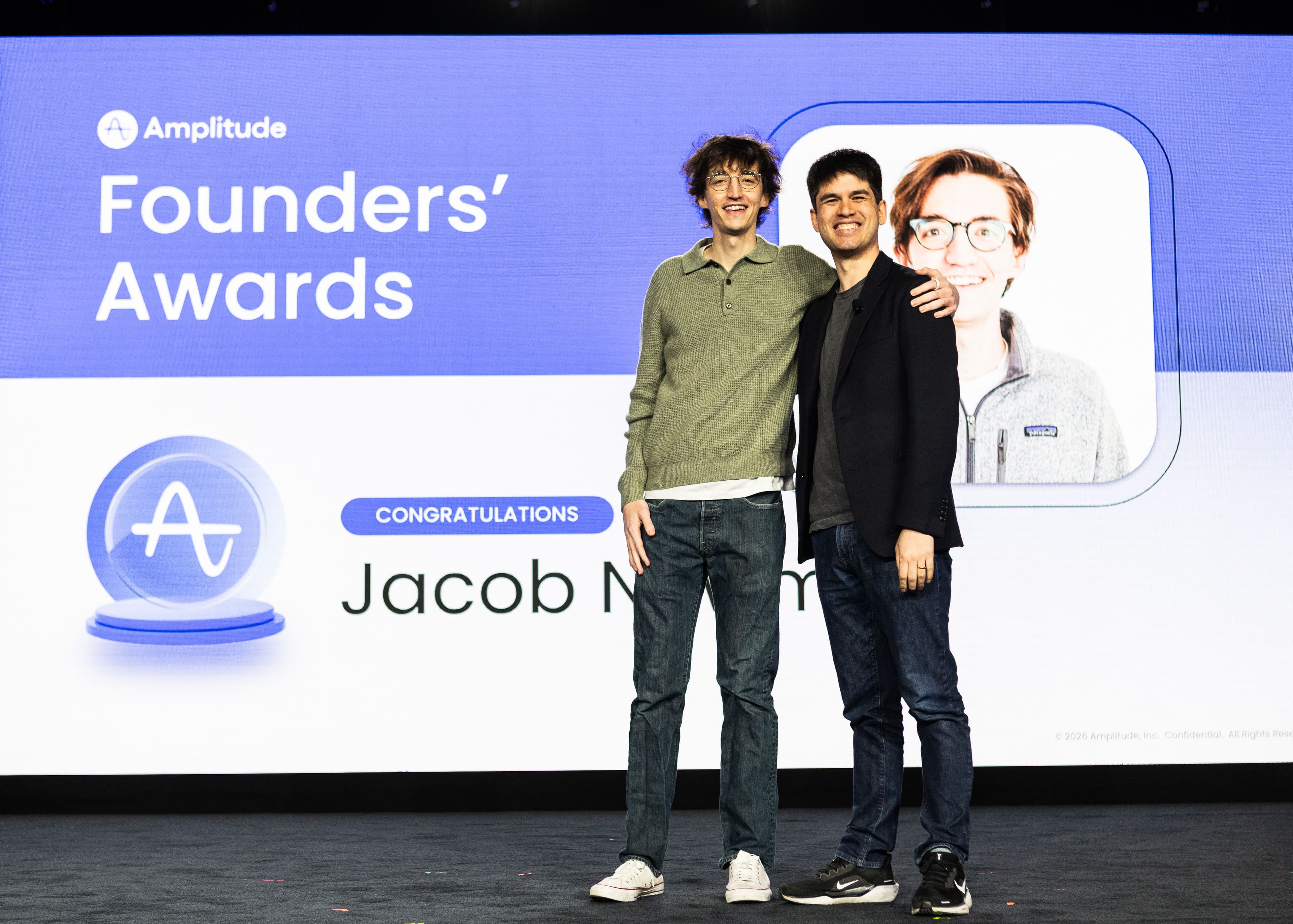 Jacob Newman with Amplitude CEO Spenser Skates on stage acknowledging his 2025 Founders' Award.
